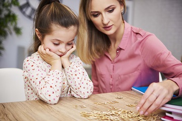 Tired and bored child and her mother studying at home Become a Teacher in Israel